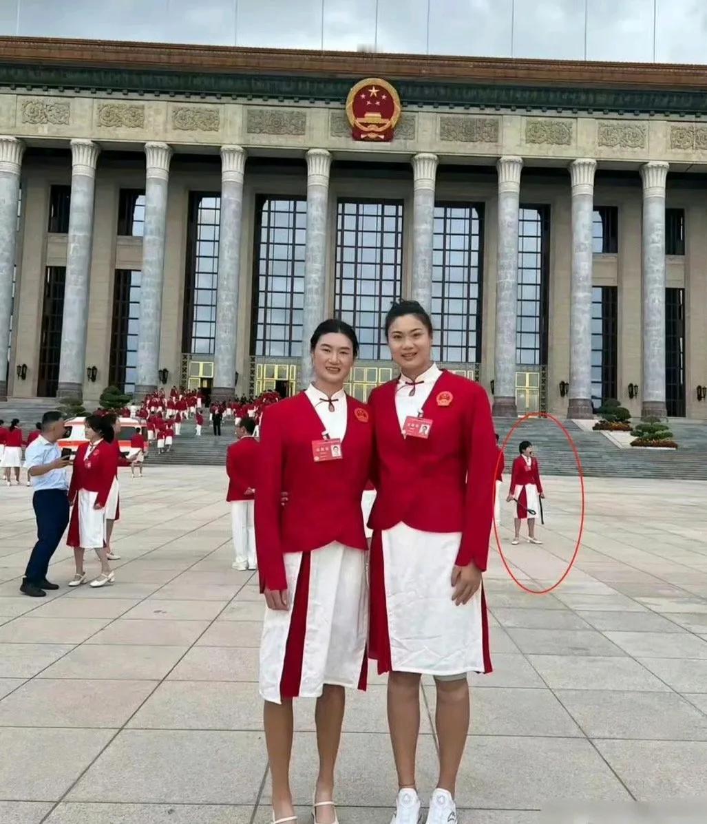 这张奥运冠军在大会堂前的合照看起来貌似很普通。不过仔细一看才发现后面有个可爱的小