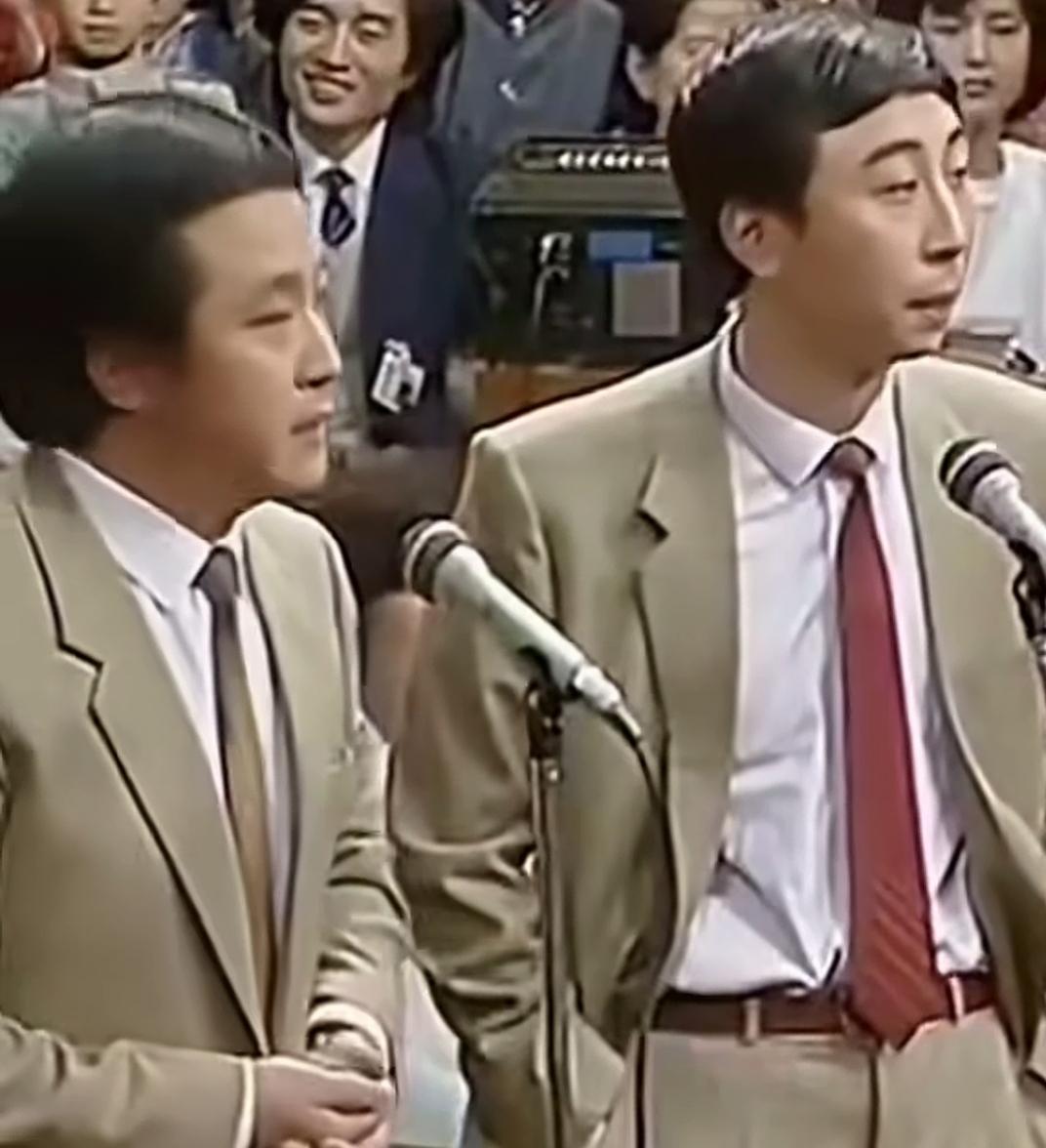 两位西装革履的男士在台上讲话。到今天为止，相声界的经典搭配就是他俩。每年的春晚相