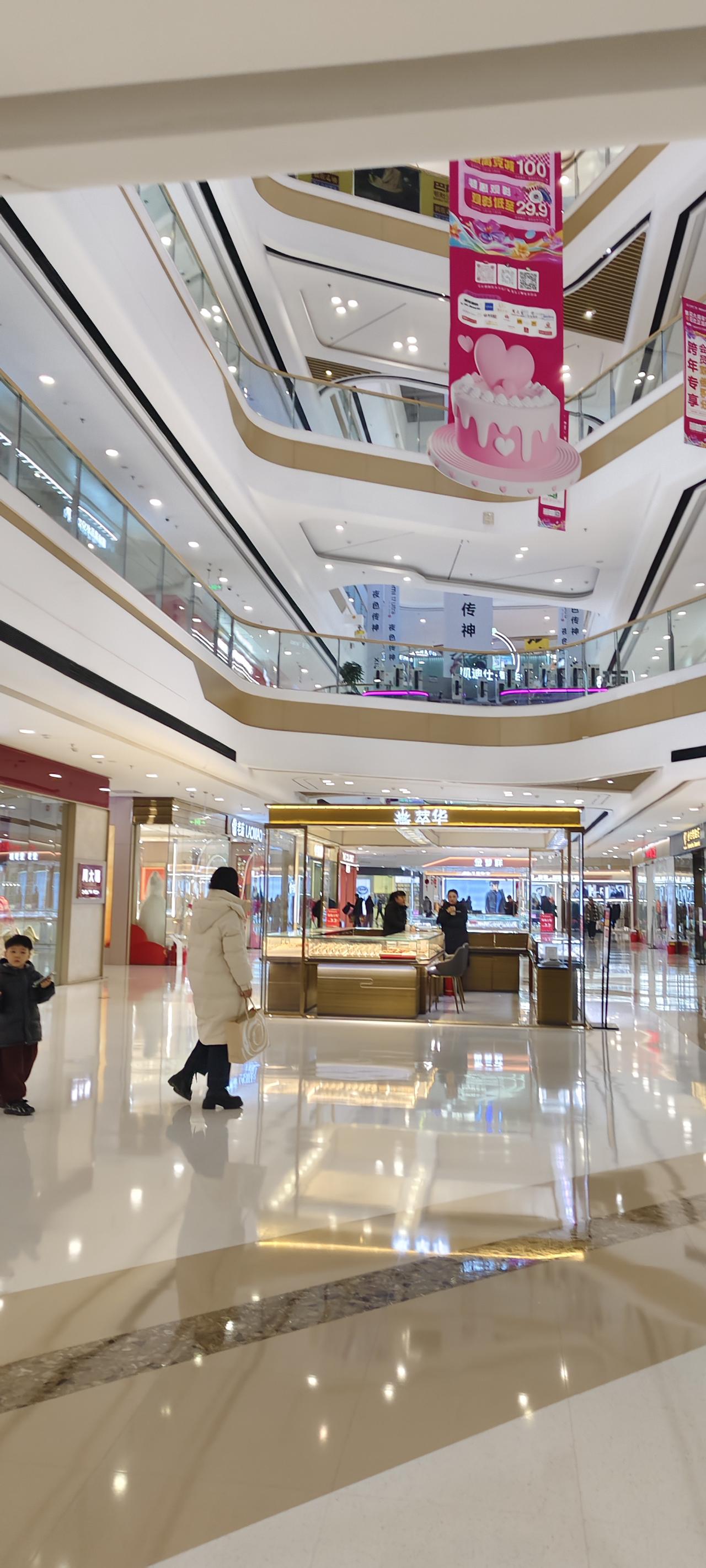 周末的商场里，人流比工作日密了不少。抬眼望去，多层的建筑结构设计得很有层次感，金