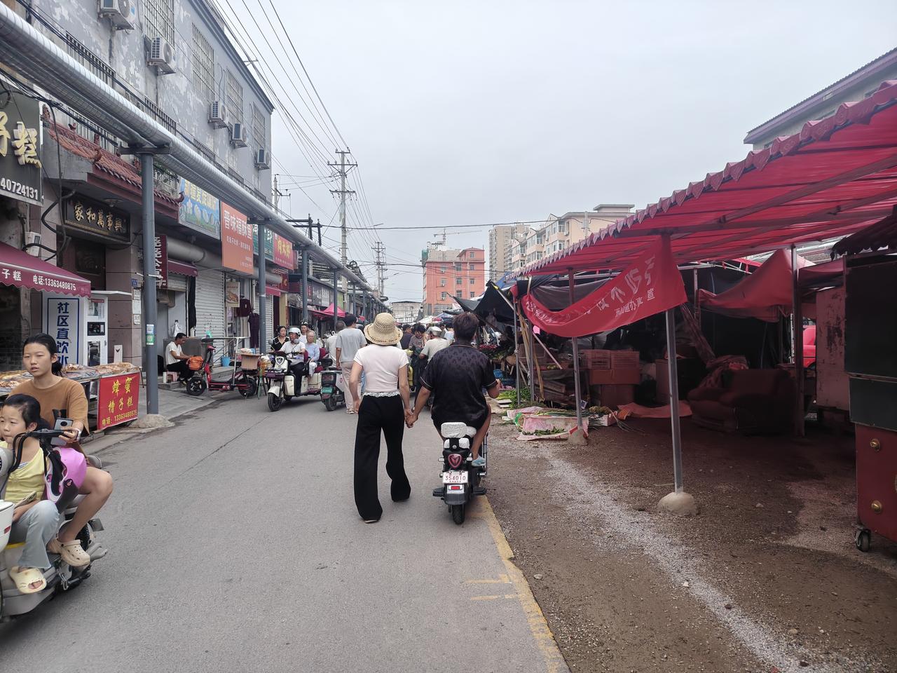 今早晨跑返回，我去西街早市上去买菜，看到一对年轻夫妻手牵手在逛早市，从背影看，他