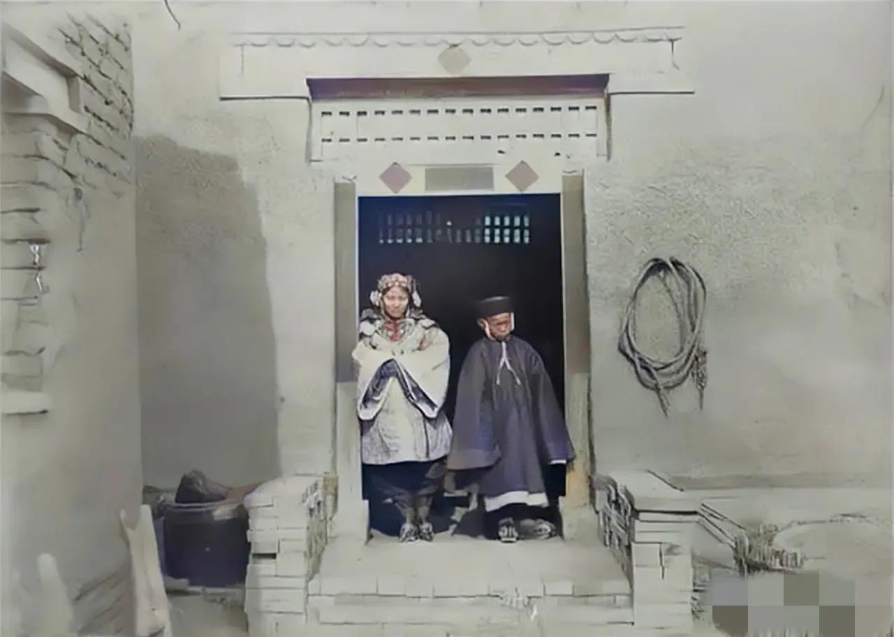 1900年，山西某地，一对“童婚”的新人站在门口前，留下了这一张照片，在那个旧社
