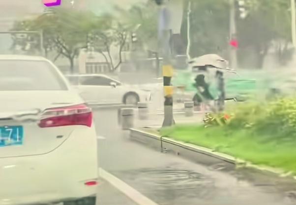 什么才是最美的人。大雨中一辆白色小轿车停在十字路口等待绿灯，车门突然打开，一位女