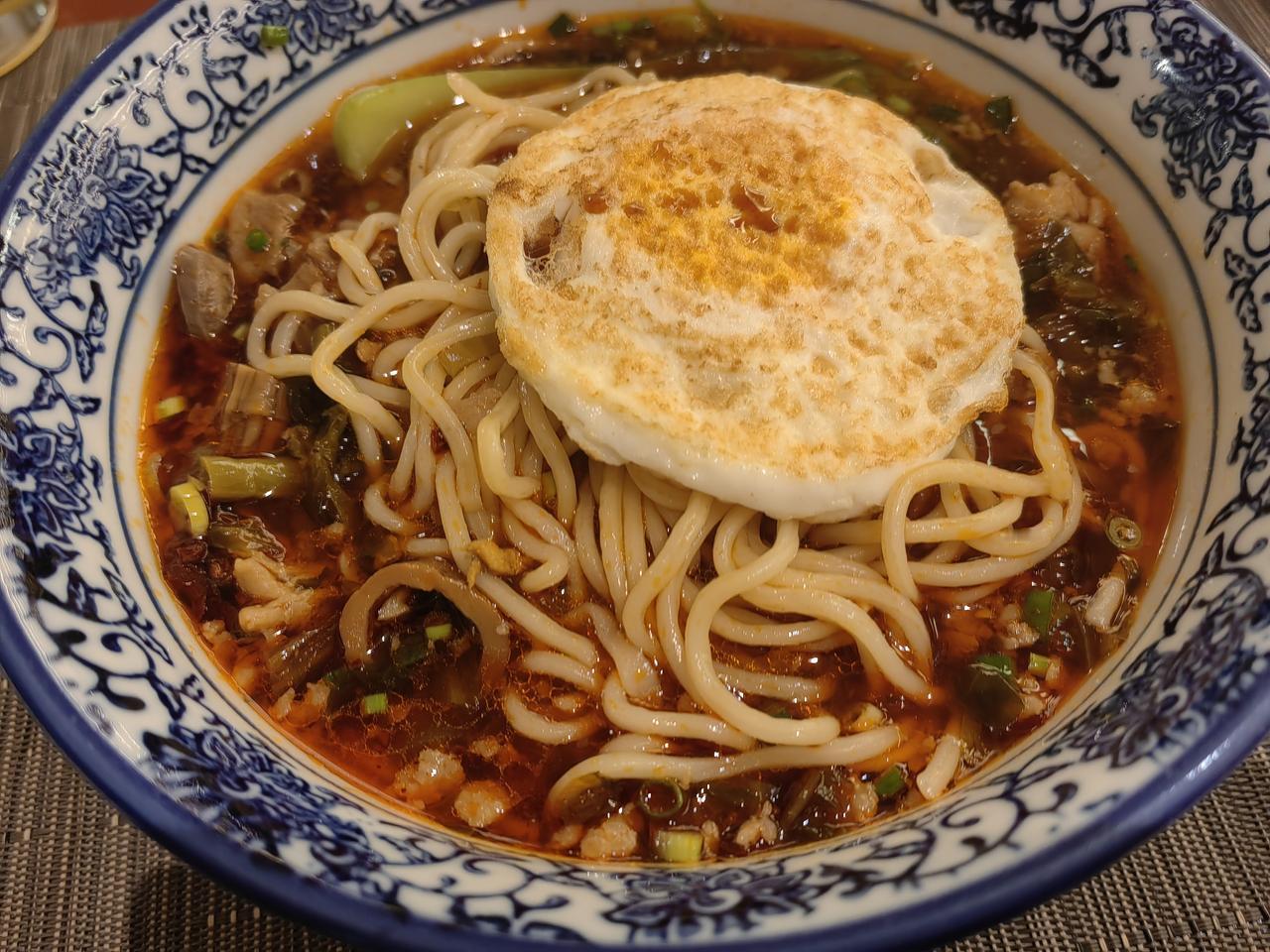 成都，宾馆的早餐面。我加了笋子牛肉鸡杂肉酱咸菜醋辣酱。相当可以。