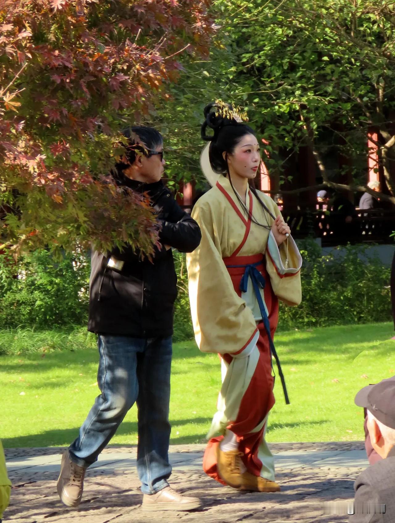 穿越时空的美丽邂逅：古装女子与现代男子在秋日公园的浪漫邂逅。