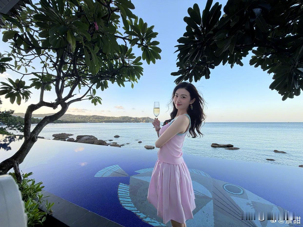 景甜笑容明媚清甜，眉眼弯弯自带温柔灵气✨
粉嫩嫩的穿搭清新灵动，临水而坐，指尖轻