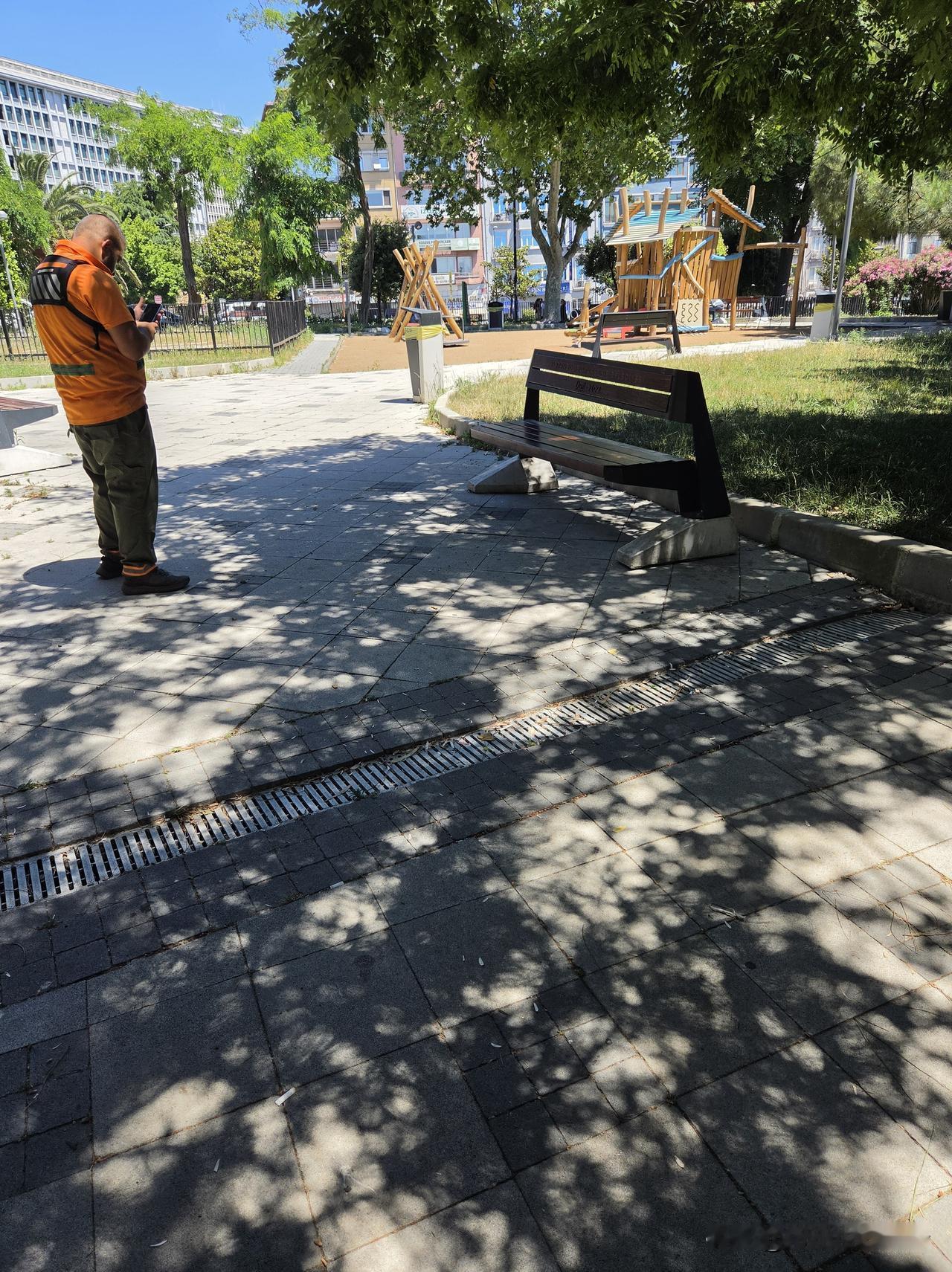 这位环卫工清扫完长椅下面的瓜子壳和烟头，也是要拍照上传系统，让老板知道干活了，这