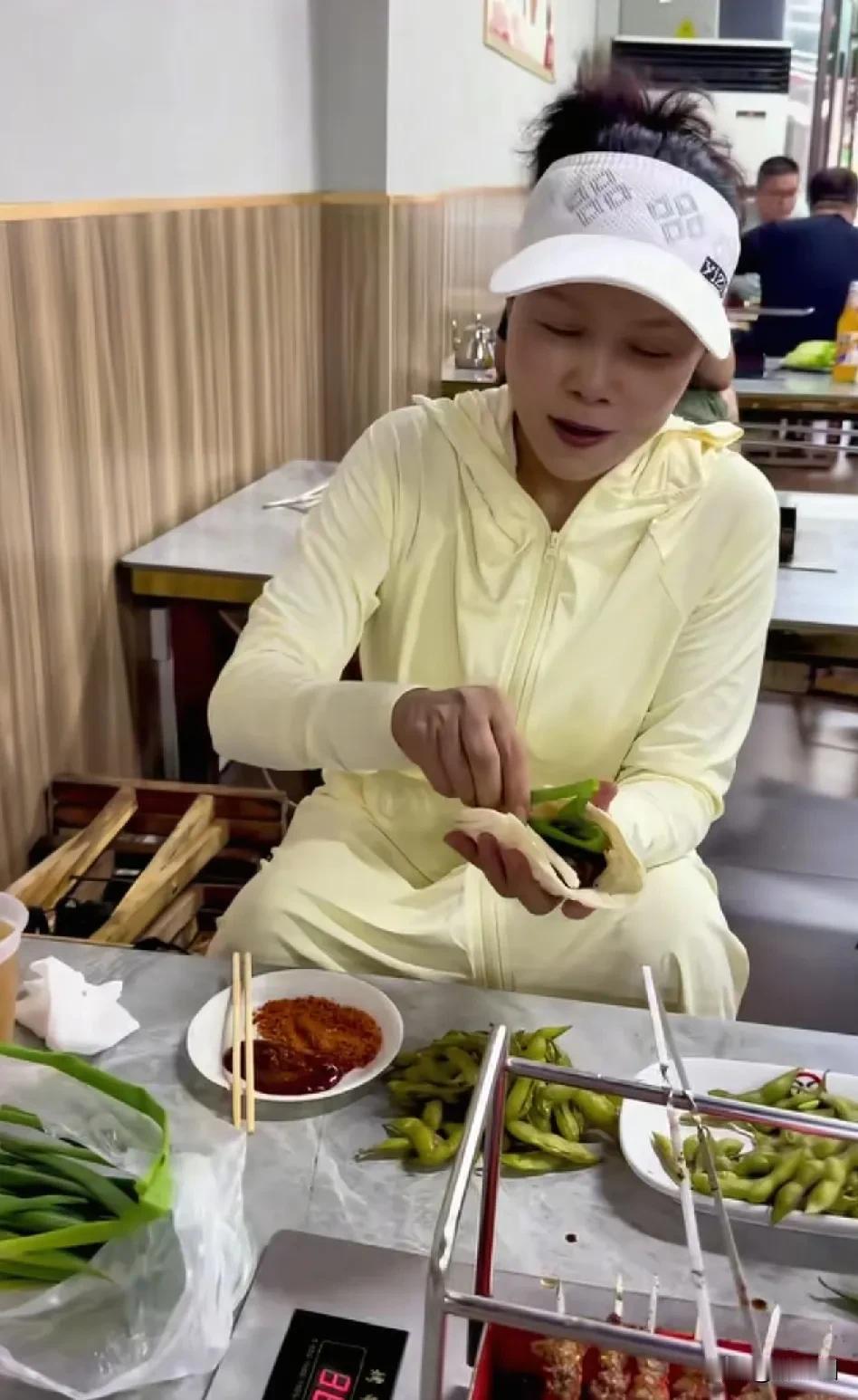 “歌星”田震山东淄博吃烤串，在薄饼上，加上葱，卷起来一口咬下去，鲜嫩多汁，蘸点醋