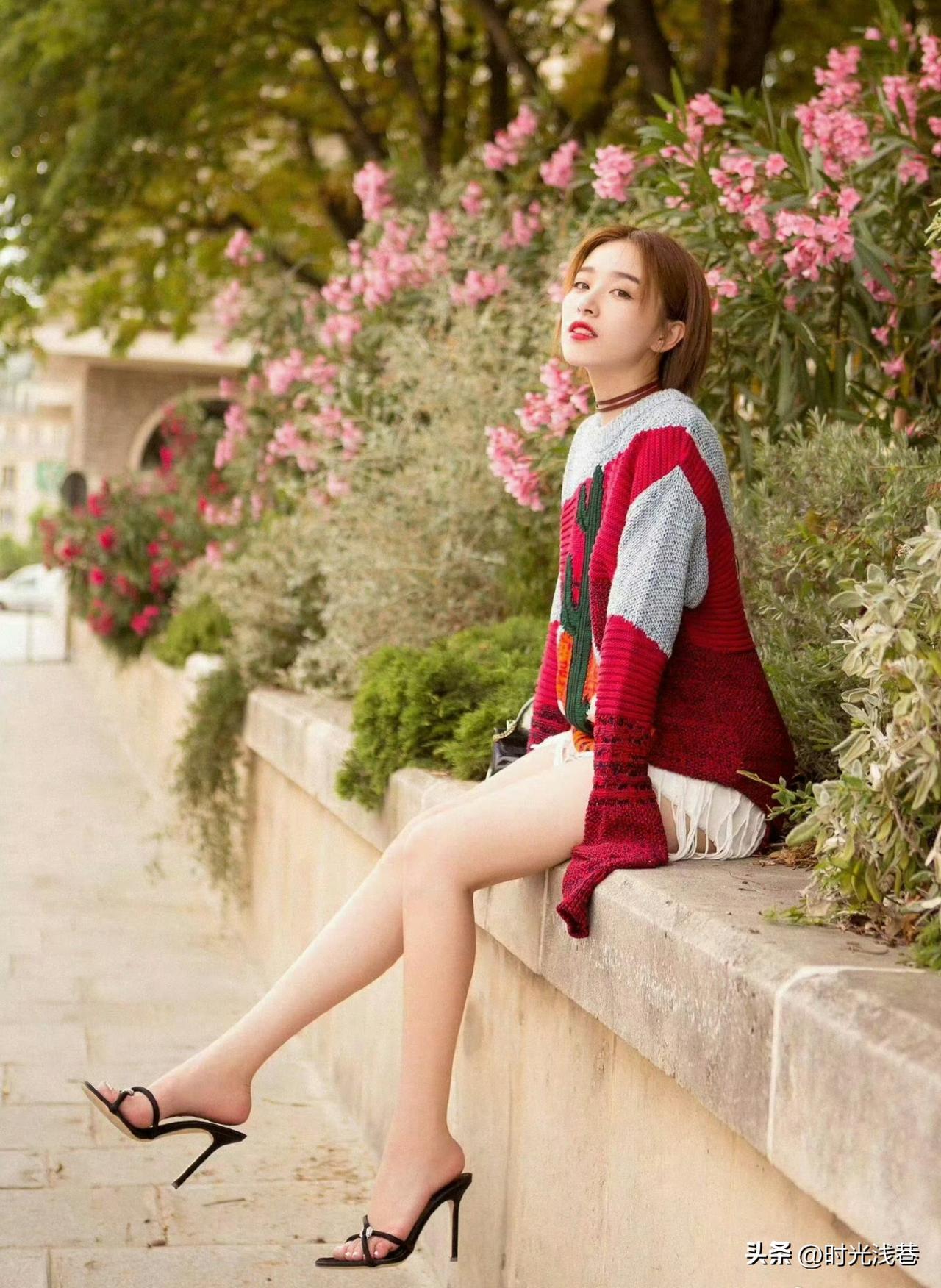 花丛边的阚清子，彩色毛衣搭配黑色高跟凉鞋，清凉时尚，明艳动人。人比花娇！
