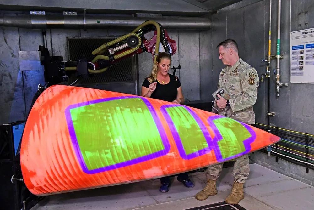 美军用机械臂修复消耗品战斗机雷达罩。
美军空军保障中心副指挥官霍尔·塞布伦上校（