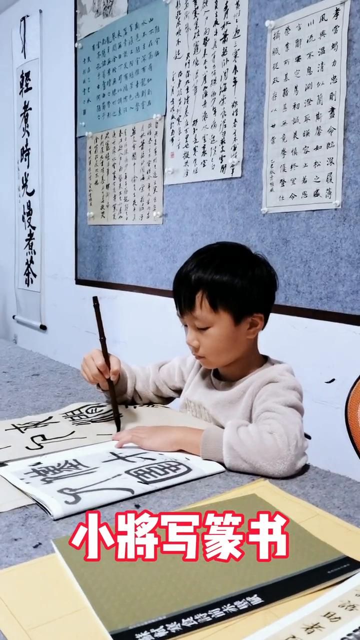 小将写篆书。