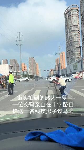 街头拍到的感人一幕！
一位交警在十字路口亲自护送一名腿脚行动不便的残疾男子过马路