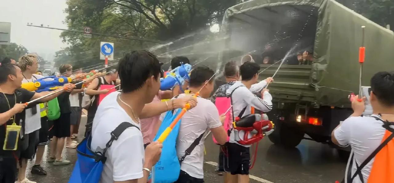 每年一度云南泼水节，人民群众拿着水枪射向我军战士，而且司机同志也很有意思，故意把