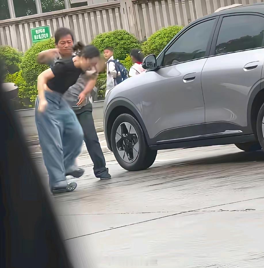 路人视角:疑似女车主和保安大哥发生争执，女车主对保安大哥抬腿一脚，保安大哥也不惯