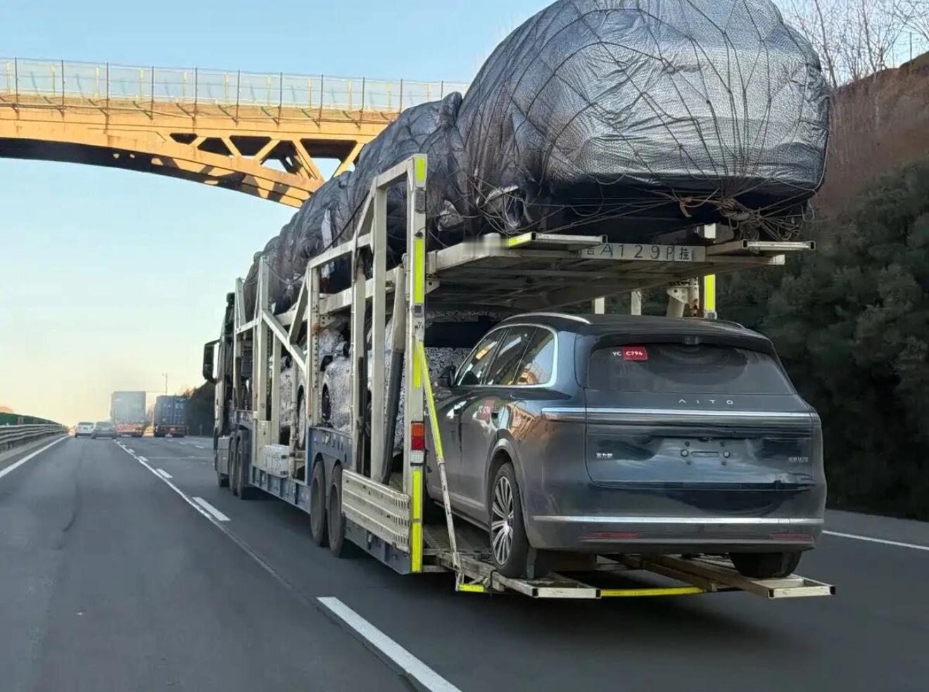 板车上好多问界，既有量产车，也有伪装的测试车。 