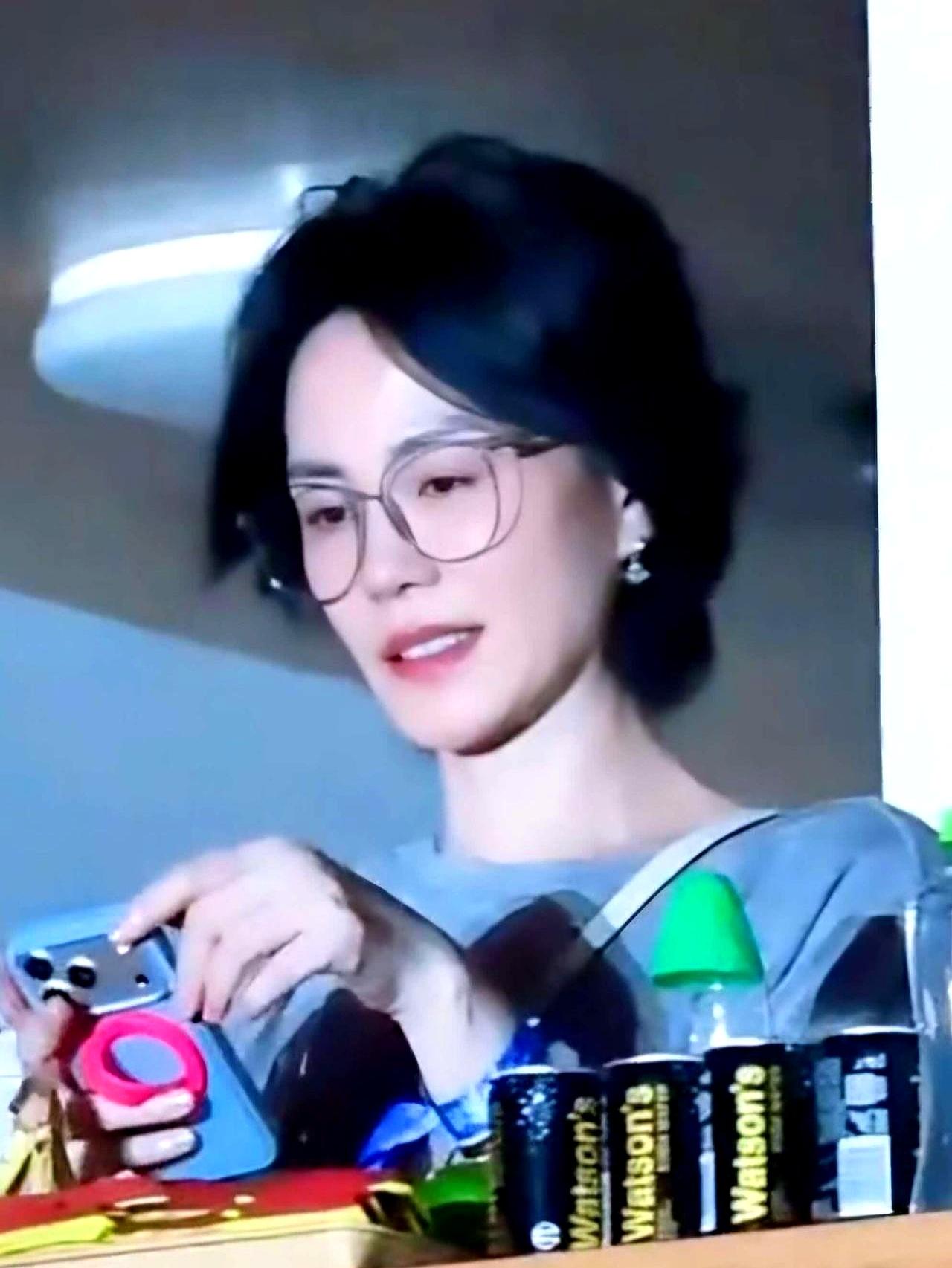 灯下那一刻, 她把手机往前一推, 镜片在台光里亮了一下, 台下有人笑, “王菲也