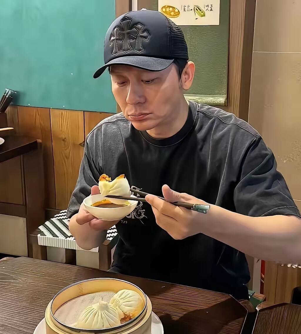吃包子的这个男士是谁，戴着帽子都有点认不出来了，估计这是在录制哪个节目的剧照吧。
