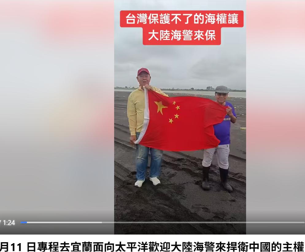 2名台湾民众于6月11日到宜兰兰阳溪出海口高举五星红旗，他们身后就是台湾的东方，