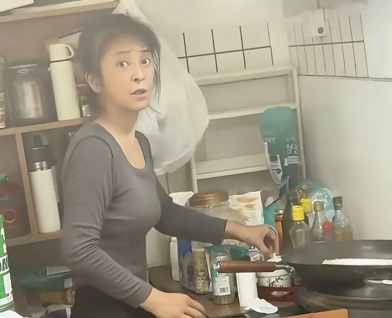 李勤勤晒出在厨房做饭的视频，又小又脏又乱，旁边盆碗杂物堆得满满当当，炒个菜都得缩