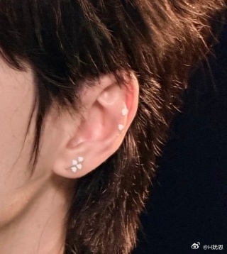 耳朵上贴了铃兰花，领口也别了铃兰花 
