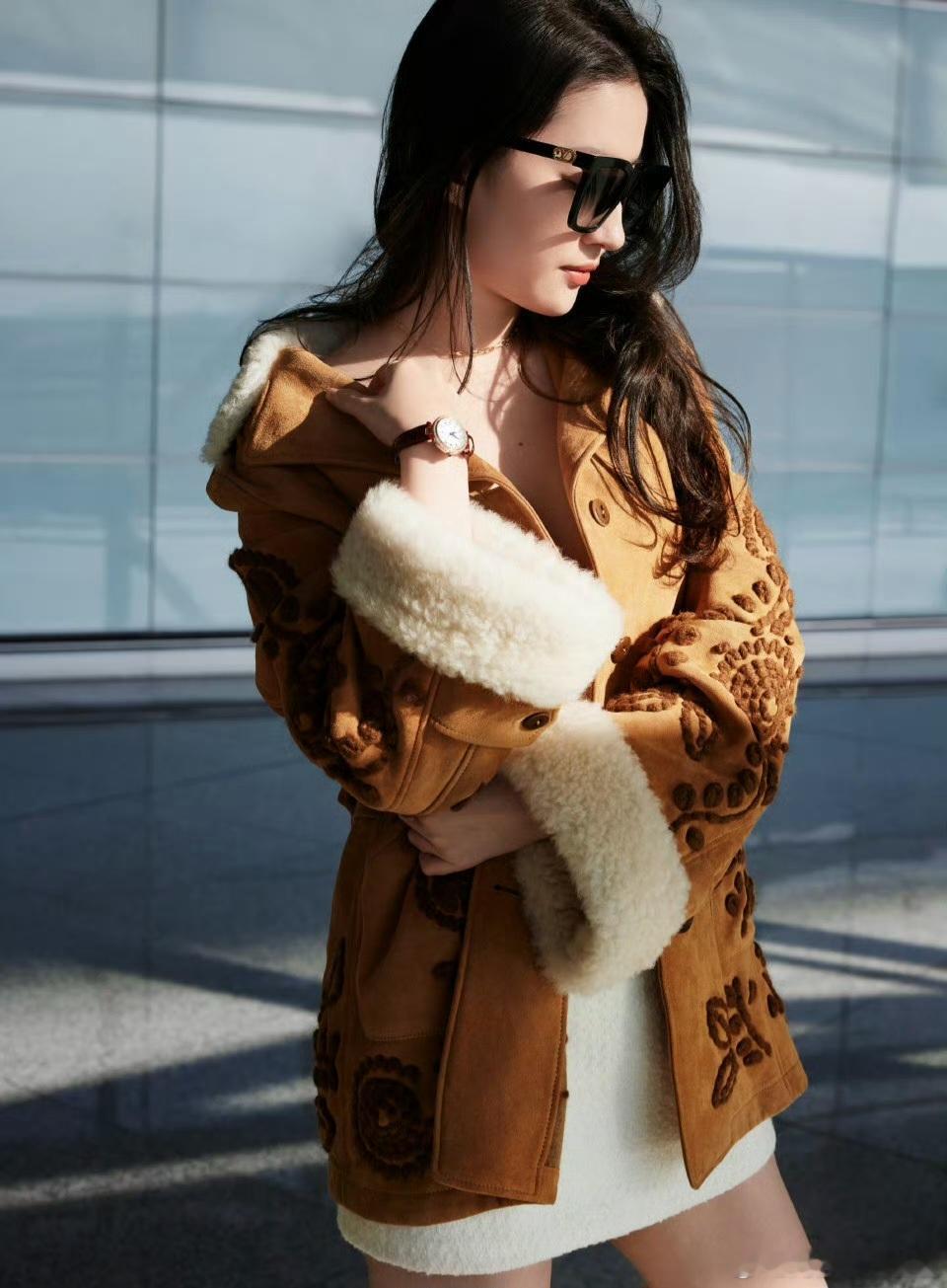 刘亦菲的这套穿搭，焦糖色麂皮翻毛大衣是亮点，衣身的立体刺绣复古又民族，翻领与袖口