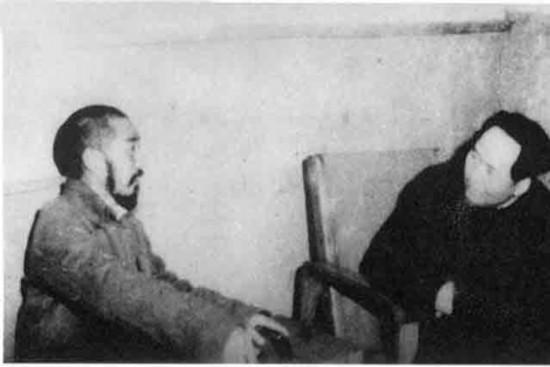 毛主席的这张合影照十分特别。照片中，毛主席坐在凳子上，身体微微前倾，双手插在袖笼