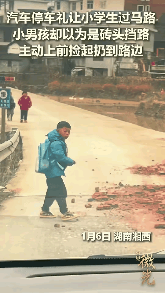 湖南湘西一女子开着小车在乡村道路上行驶，在行驶的路上看到右边前面被碎砖挡住了，左