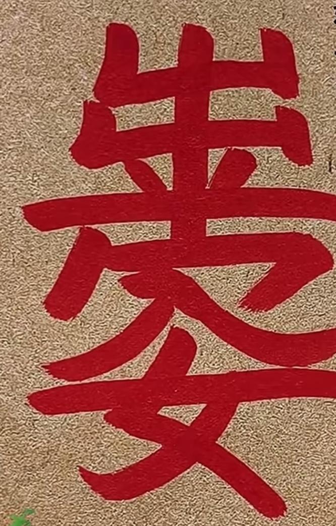 这红字在米色背景上显眼极了。这几个红色的大字写的很特别。意义非凡。谁能读出来听一