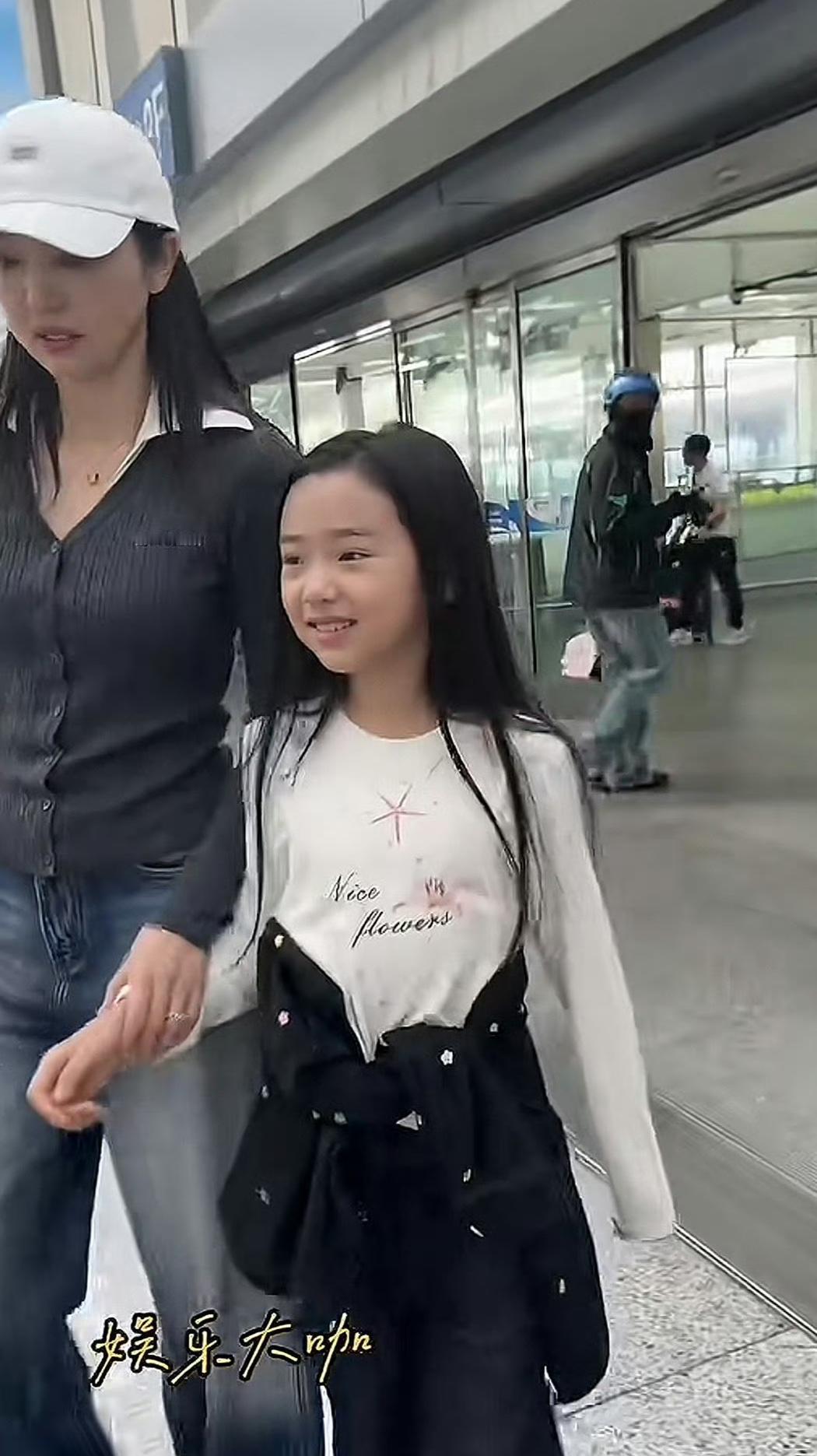 路人冲她喊“当女儿吧”，她没笑，低头牵紧了小酒窝的手。
那孩子刚走完上海时装周，