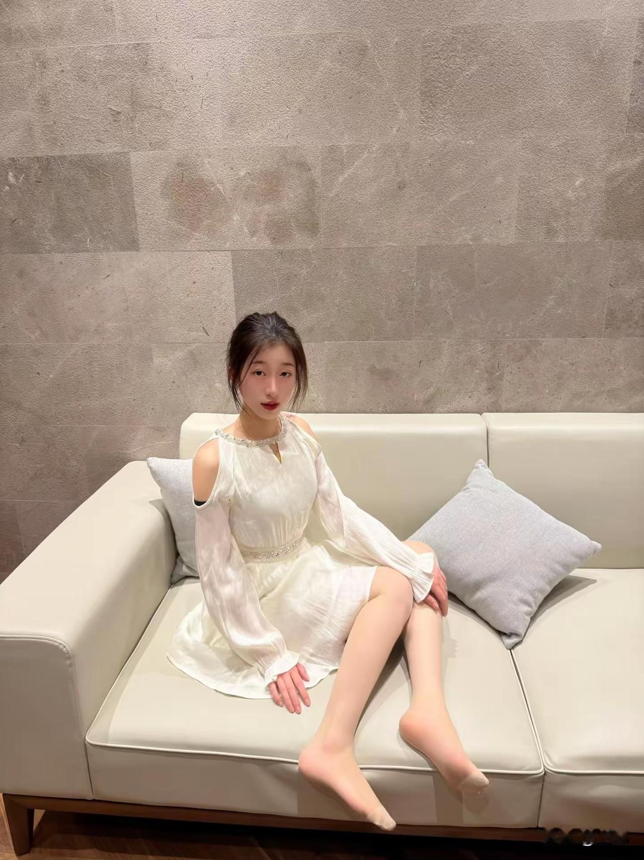 想象一下，一袭优雅白裙，静静坐在沙发上，那画面简直绝了。就像杨幂，身着优雅白裙坐