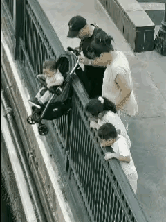 家长心太大！一家六口来到海边看风景，坐在婴儿车上的小男孩看见大海后非常的开心。于