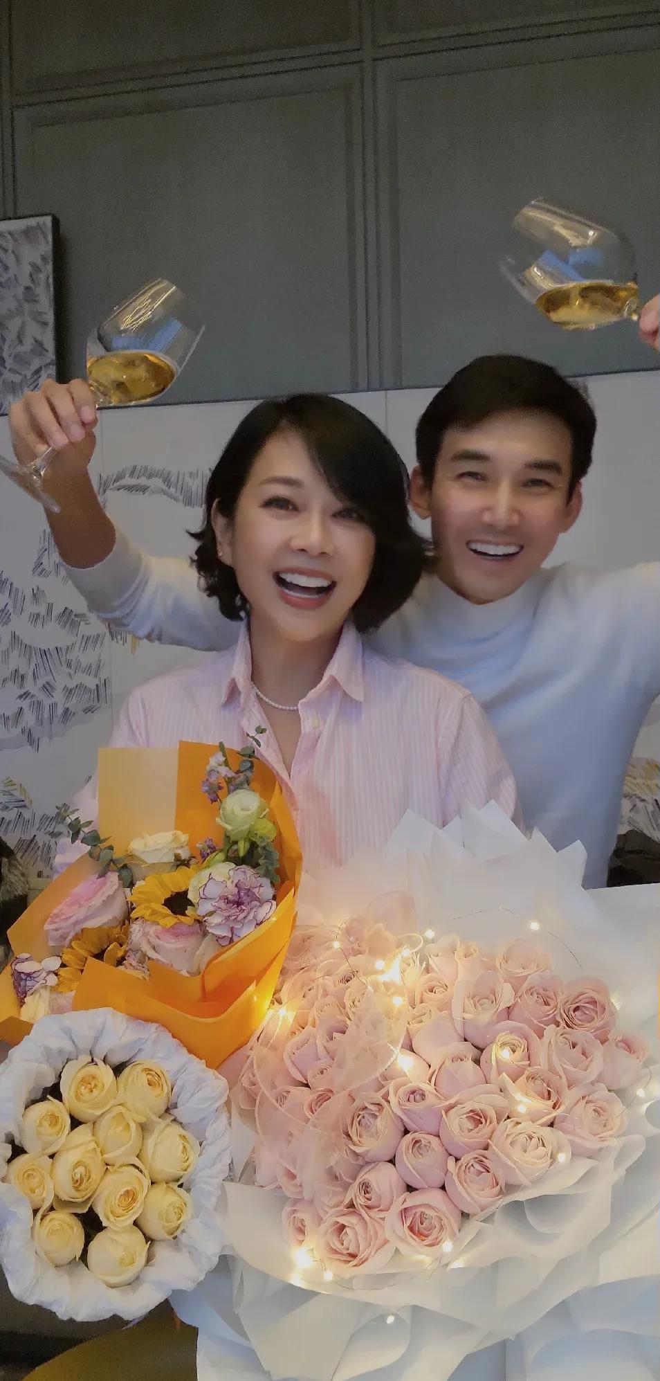 演员张铎为妻子陈松伶庆祝53岁生日，夫妻俩感情真好。陈松伶捧着三大束鲜花，笑容灿
