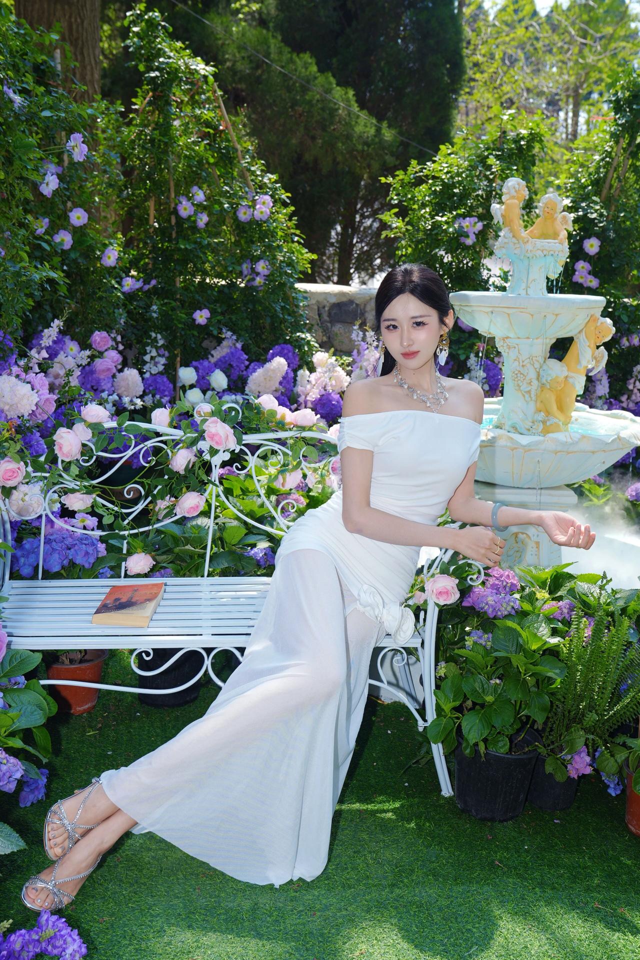 🌷 花园秘境里的白裙仙子
她身着一袭白色一字肩长裙，是落入紫色花海的月光精灵。
