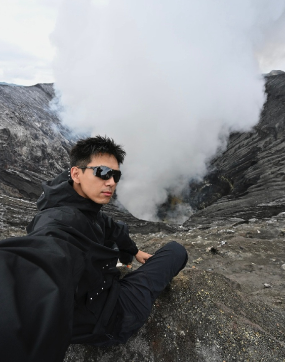 李现前往 Bromo 火山完成打卡，晨光中定格的身影与火山浓烟、熔岩平原同框，自