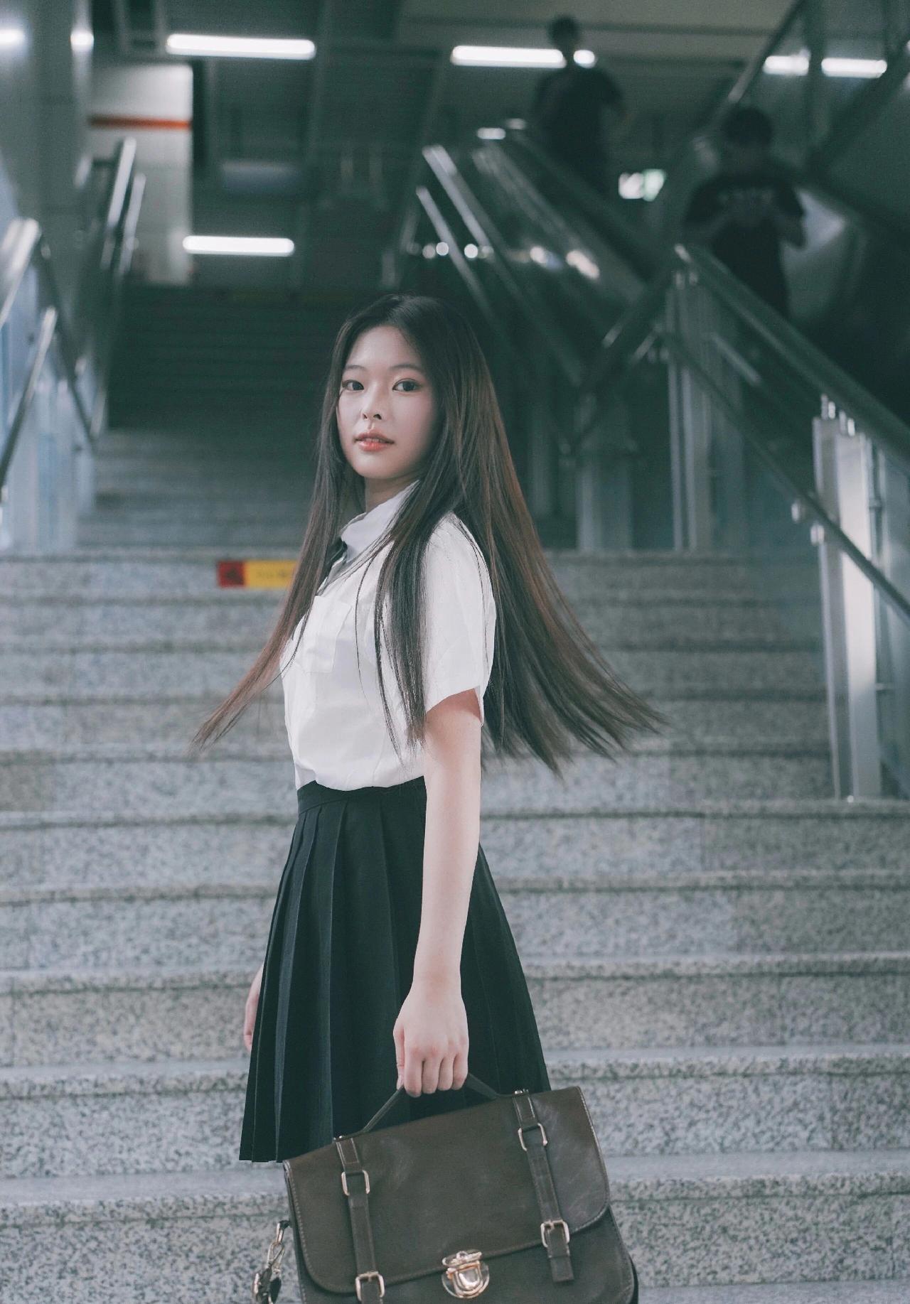 校园少女风，青春洋溢，背着小包，走在楼梯上，阳光洒满脸庞。