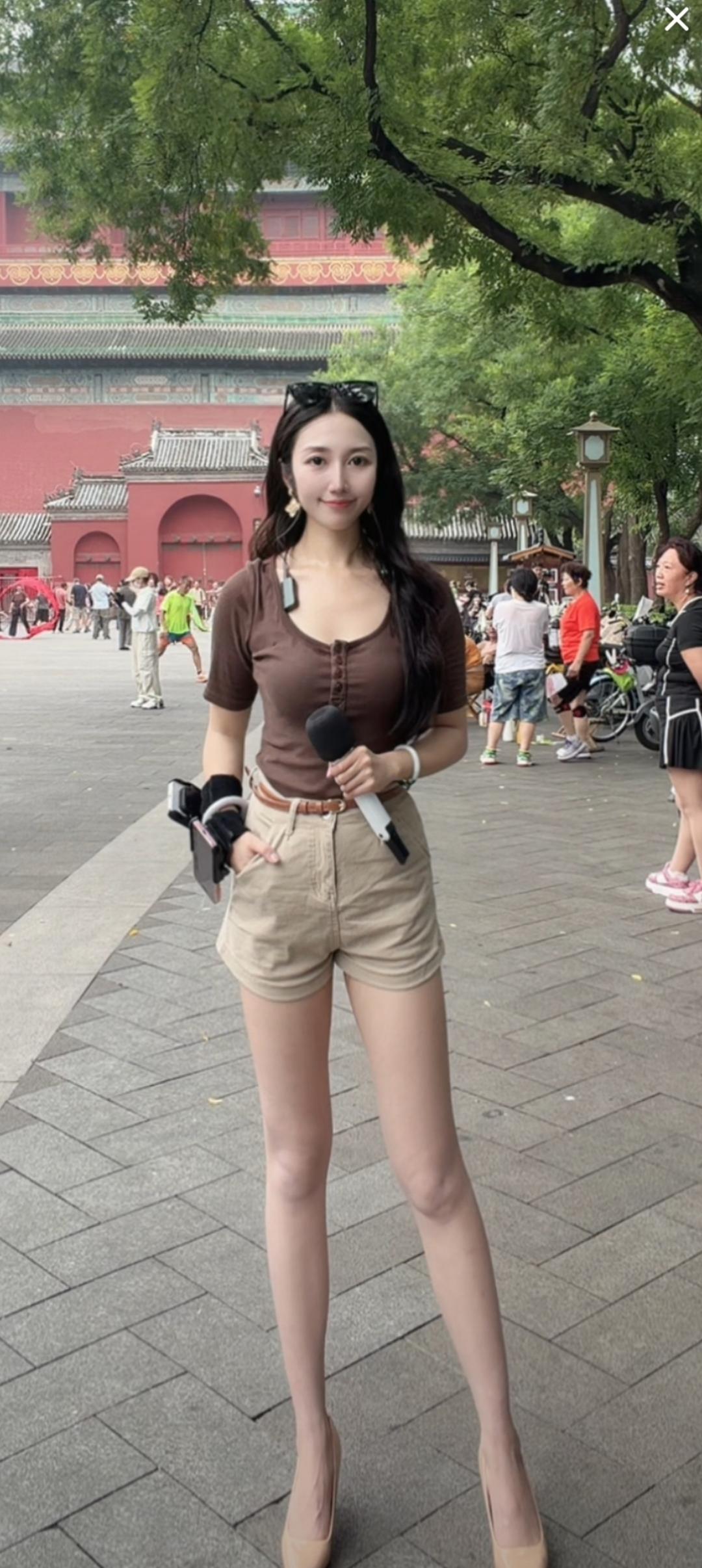 这个美女拿着话筒在户外。