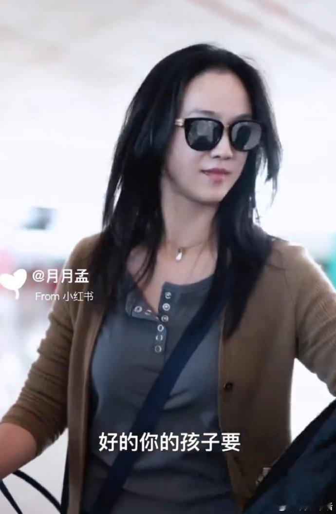 汤唯女儿帮妈妈拿衣服 汤唯在机场插兜，意外掏出女儿橡皮擦，而女儿正乖巧帮她拿衣服