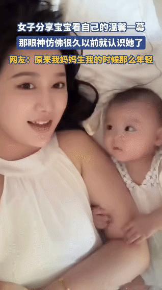 宝宝清澈的眼睛紧紧盯着女子，那份超越陌生的亲昵仿佛与生俱来，瞬间融化了时光。女子