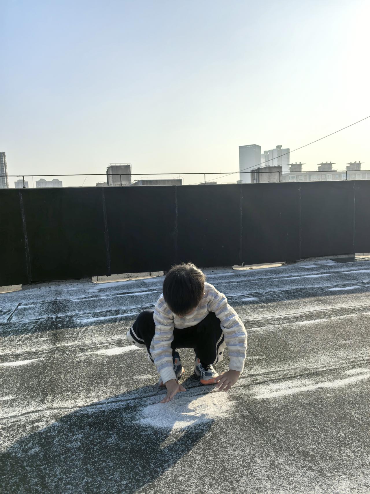 冬日午后，和儿子在楼顶晒太阳。

沙堆旁他玩得很专注，我忽然有点恍惚——记不清多