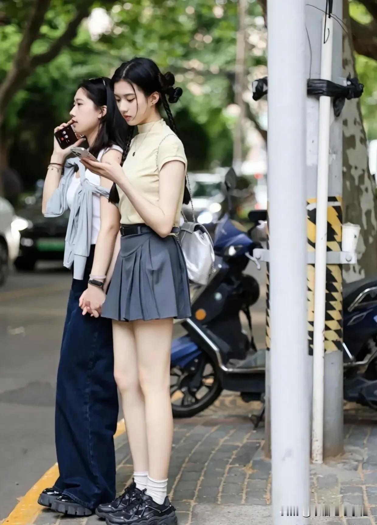 街头佳人笑语，手机轻触屏。