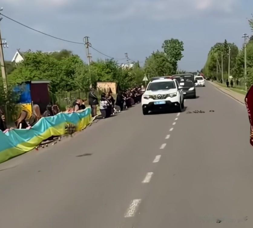 看看乌克兰民众自发地跪在道路两边迎接为国战死的军人灵车经过的路段，这种向死而生为