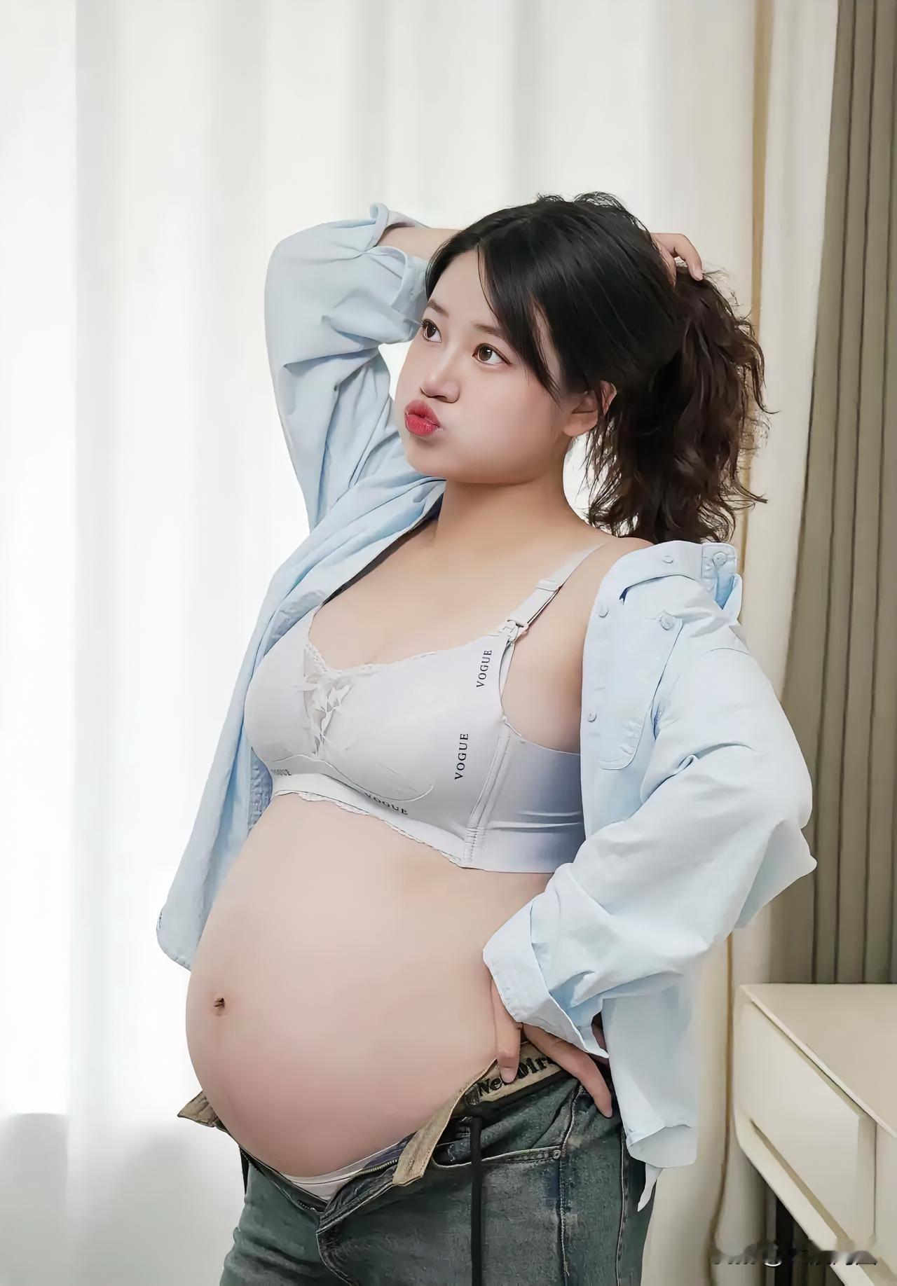 这孕妇穿着牛仔裤和衬衫，看起来好可爱。