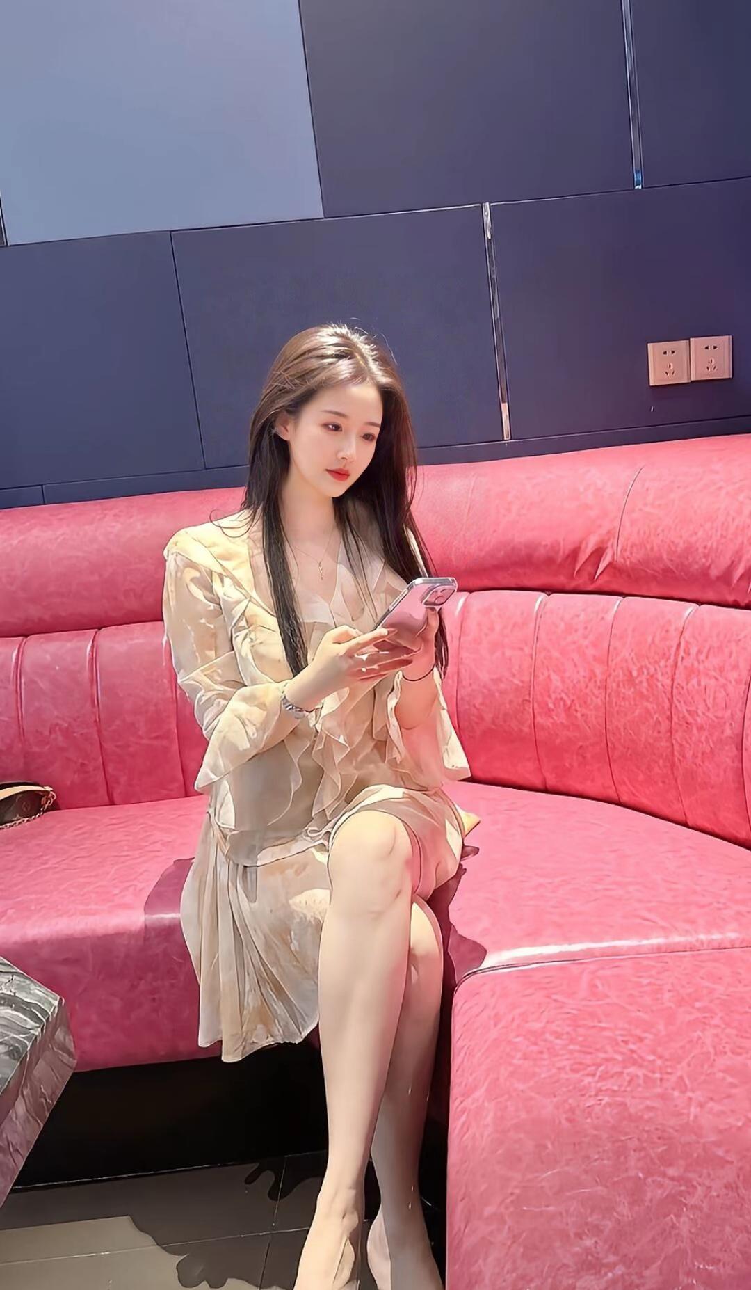 优雅少女在粉色沙发上享受阳光，沉浸在手机世界