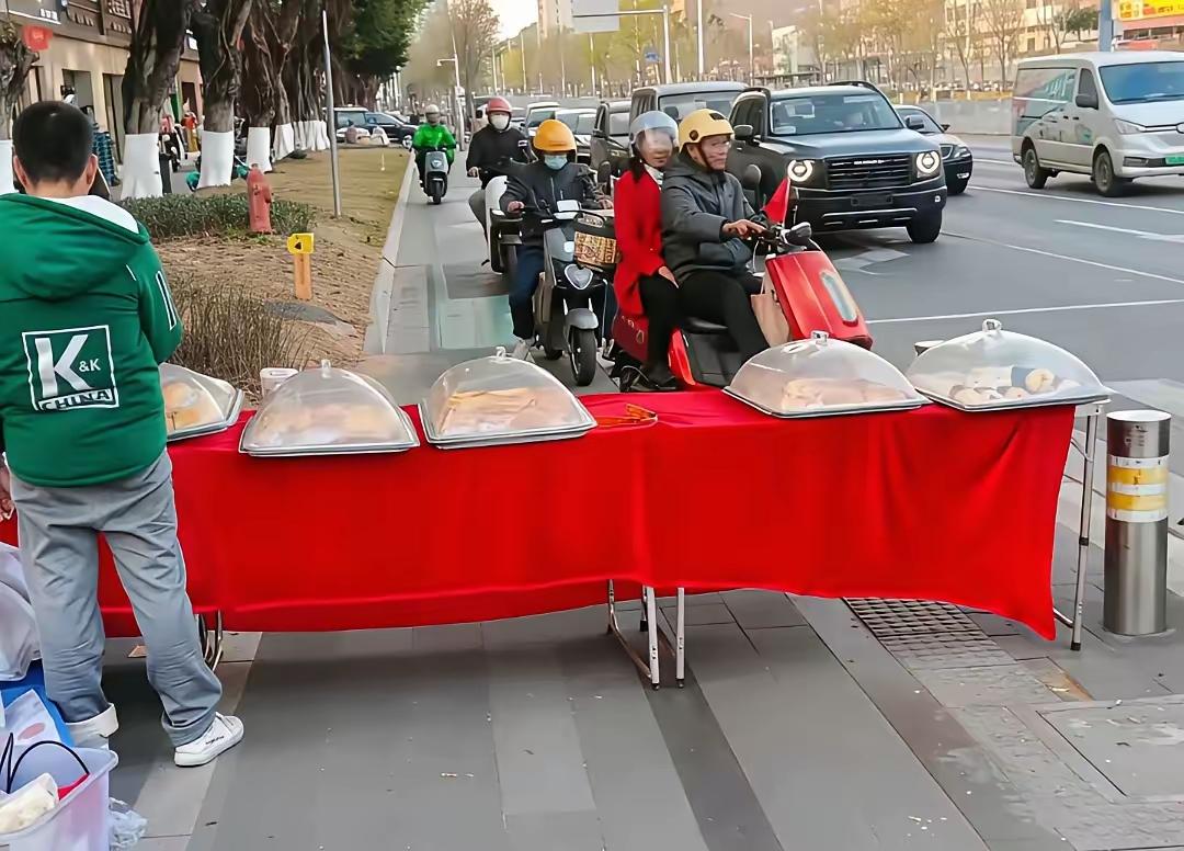 太过分了，这位小哥为了挣钱，不惜堵住非机动车道，直接把摊位“腰斩”道路，严重影响
