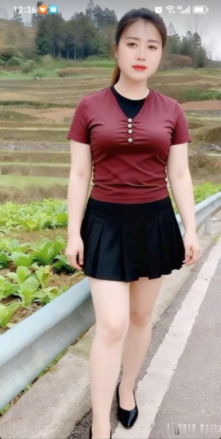 她站在田间小路上，身着红色上衣与黑色短裙，画面顿时添了别样色彩。这如同有人穿银色