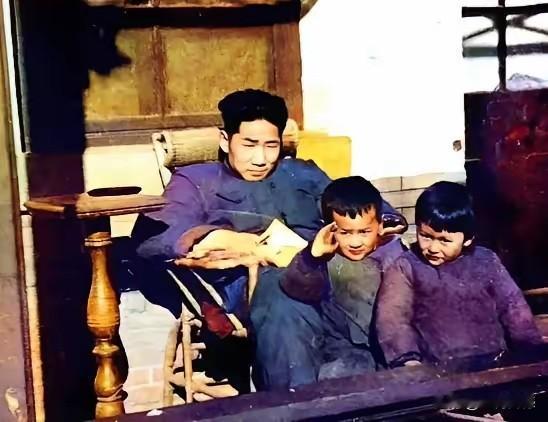 毛岸英坐在竹椅上，好像正在看着书，或是其他资料，站在他前面的这个两个小朋友，岁数