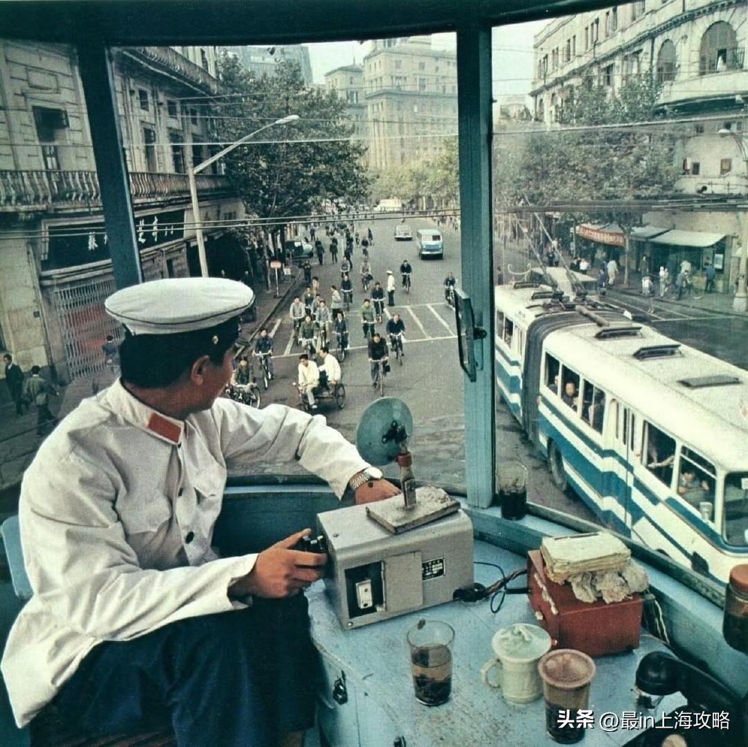 1980年的上海，交警在岗亭内手动切换红绿灯，确保交通有序。尽管科技水平不高，但