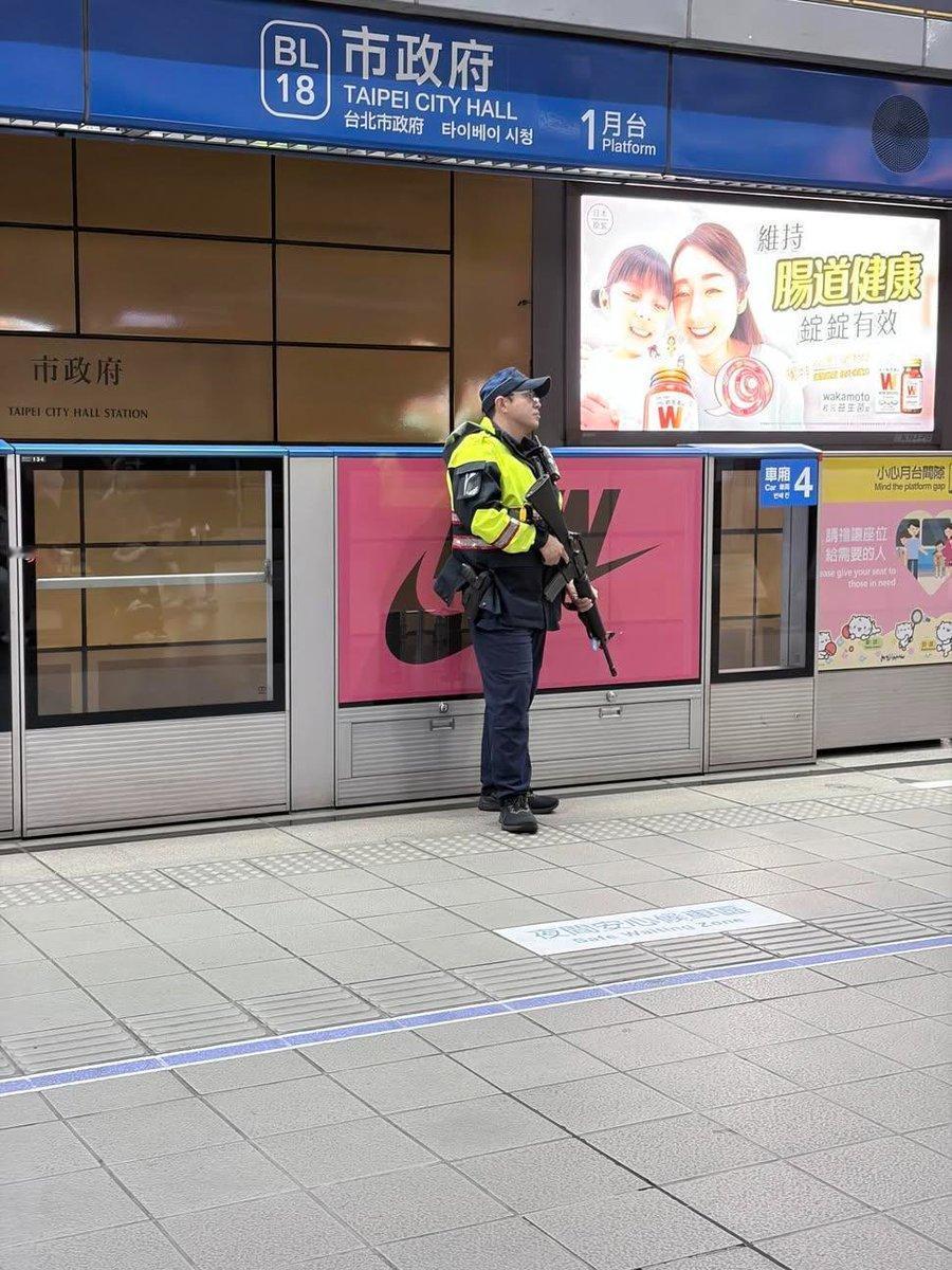 照片中一名身穿制服的警员在台北市政府捷运站公开携带突击步枪。这是对2025年12
