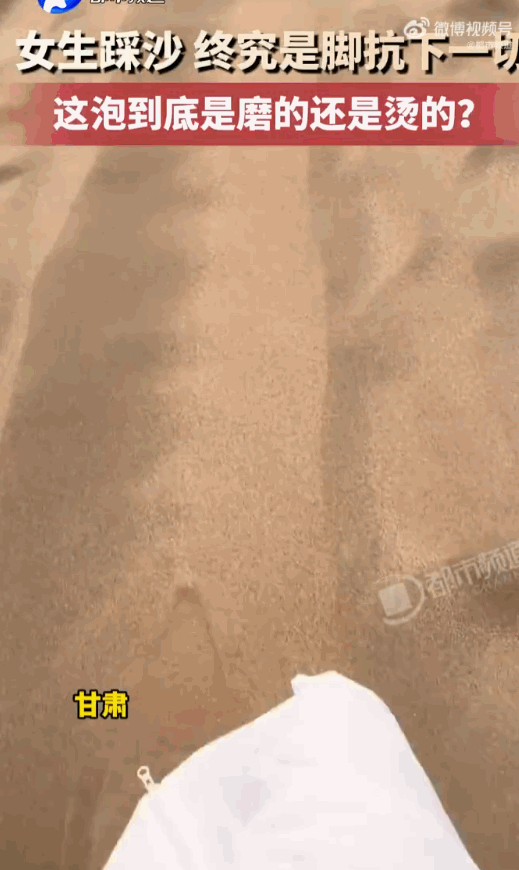 百思不得其解！甘肃的一处沙滩上，一位年轻姑娘穿着袜子踩沙戏水，本想图个干净防烫护