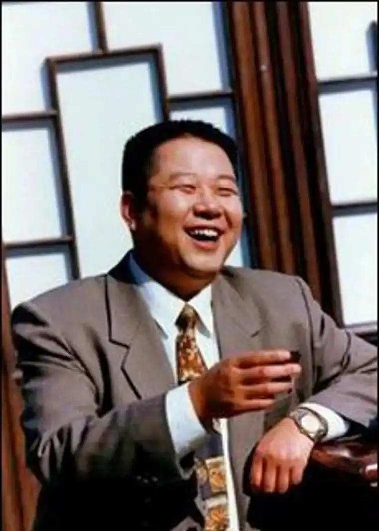 2004年，48岁的演员牛振华因车祸去世。镜头下他身着西装，安详地躺在鲜花丛中。