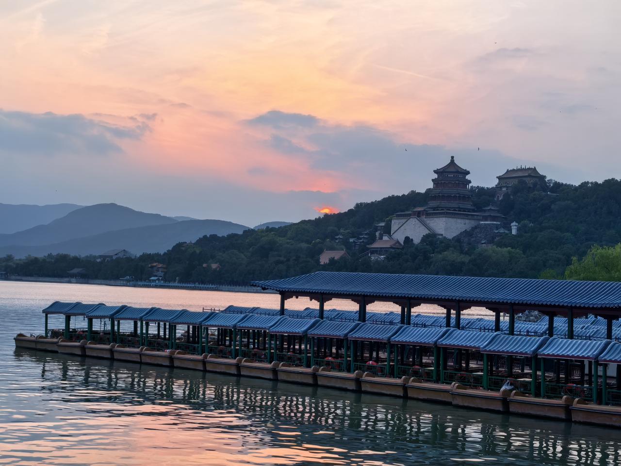 傍晚的颐和园，美得让人移不开眼。

天边的云霞像打翻了的调色盘，绯红、橙黄浅蓝层